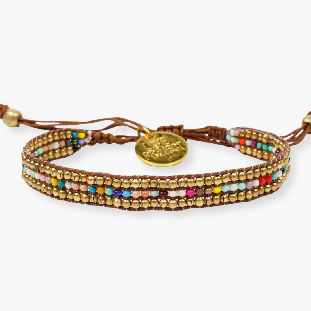 Brown leather wrap bracelet with three rows of small gold beads interspersed with tiny multicolored beads featuring a prominent gold Love Project charm and adjustable knot closure