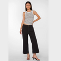 Photographic image of a woman modeling a white and black striped tank top, black wide-leg cropped trousers with a brown button, and strappy black kitten heel sandals on a white studio background