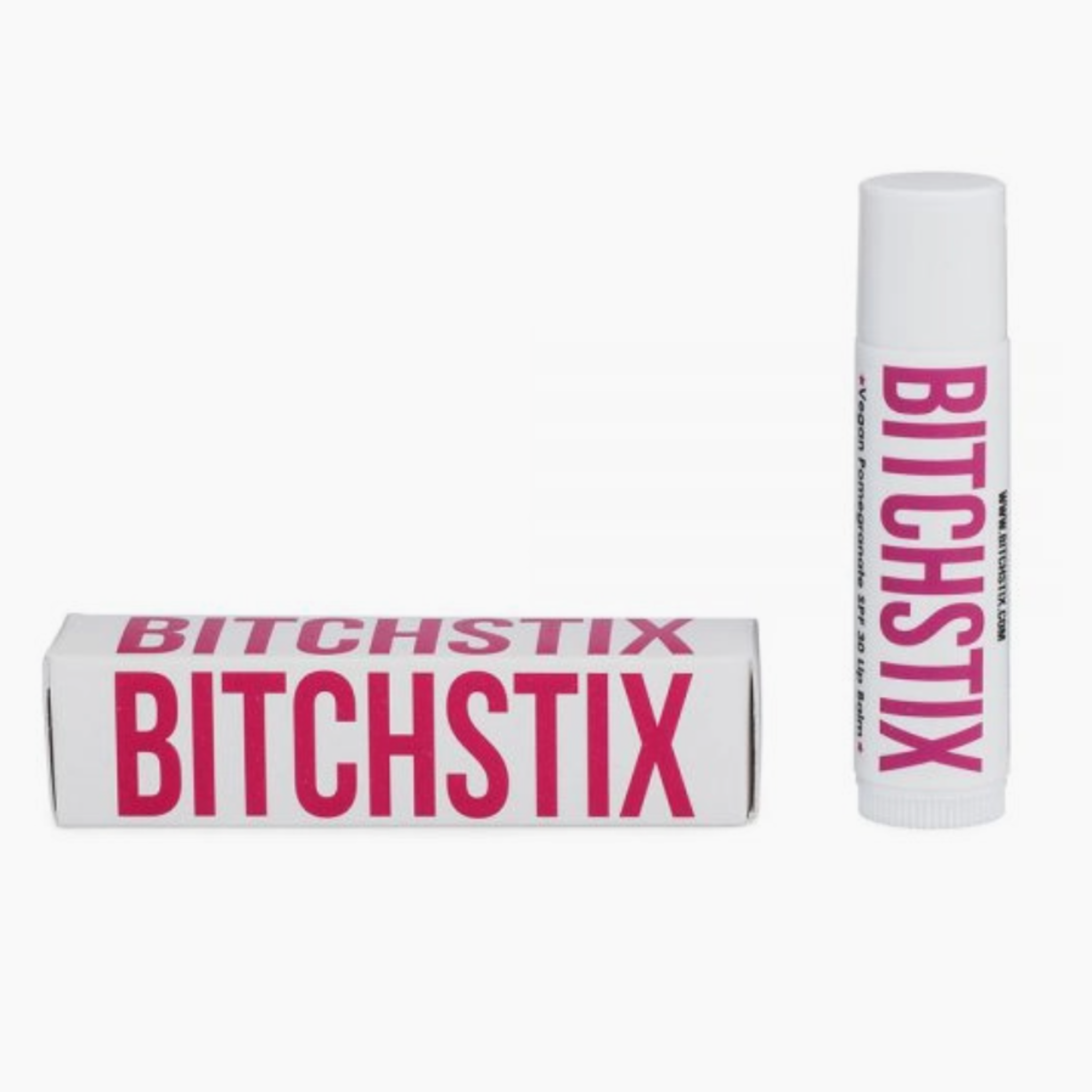 Two Bitchstix lip balm products on a white background, featuring white packaging with bold pink 'BITCHSTIX' text, one as a rectangular box and the other a cylindrical tube labeled 'Vegan Pomegranate SPF 30 Lip Balm'