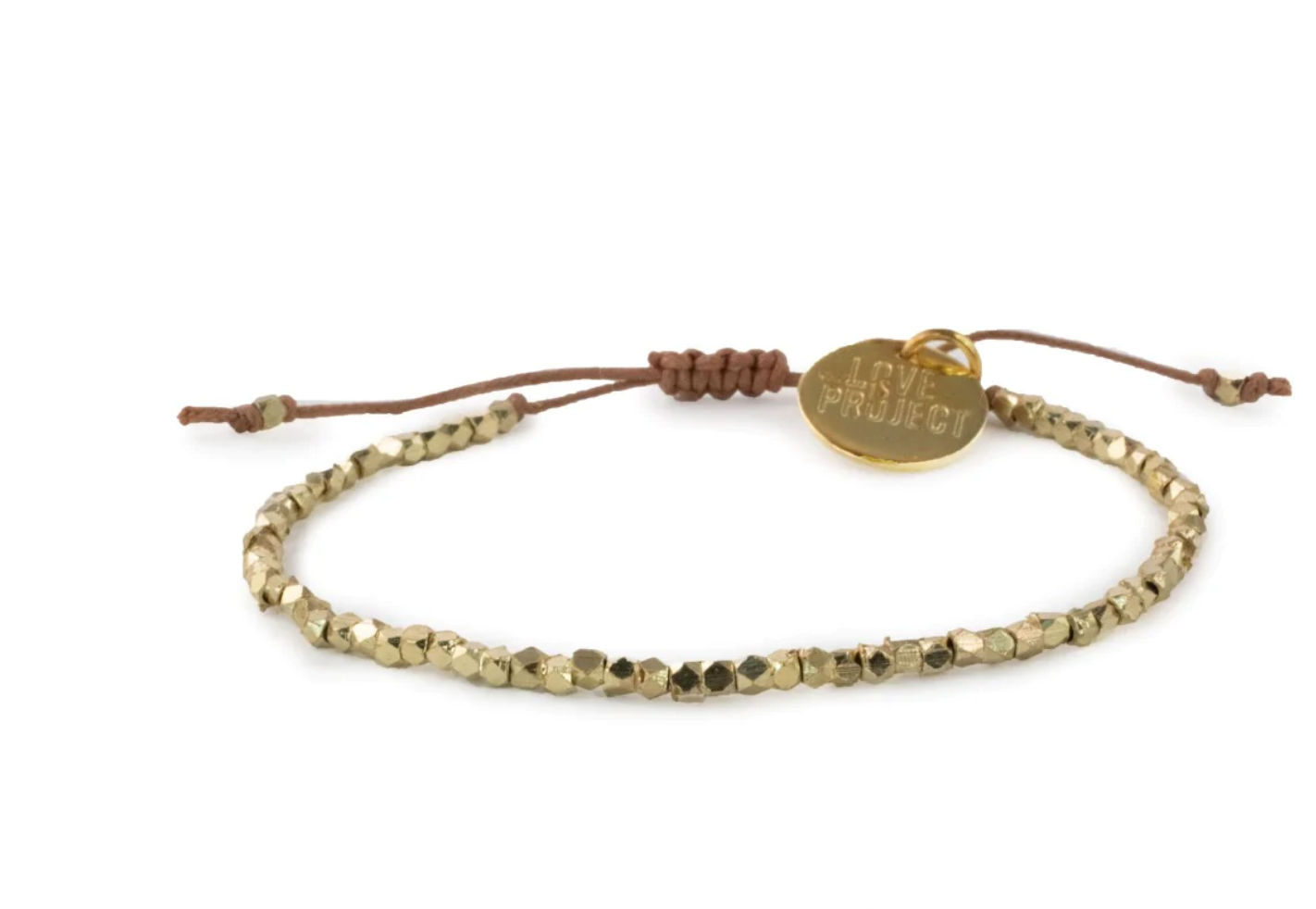 A delicate bracelet featuring numerous small gold-colored faceted beads strung on a brown adjustable cord, adorned with a round golden charm distinctly engraved with LOVE PROJECT